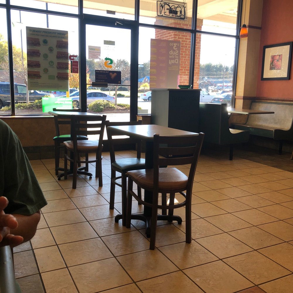 Subway - a man sitting at a table in a restaurant - Sandwiches Near Me - Pfafftown, North Carolina