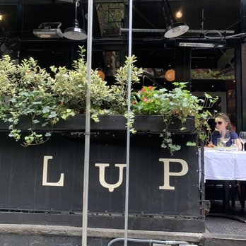 Lupa - the outside of a restaurant with tables and umbrellas - Italian Near Me - New York, New York