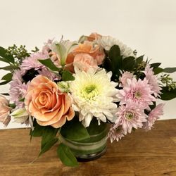 Basic Bitch Blooms - Pastel Simplicity - featuring peach roses & carnations, lilac & white chrysanthemums and white alstroemerias in a faux leaf wrapped vase.