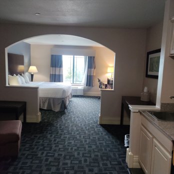 Best Western Plus Kalamazoo Suites - My beautiful clean room with a king size bed and a humongous tv. Then a sitting area and a kitchenette. Nice size shower and tub. - Hotels Near Me - Kalamazoo, Michigan