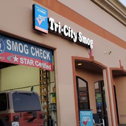 Tri-City Smog - Exterior view of Tri-City Smog facility showing STAR Certified smog check signage, test-only garage bay, and customer entranc...
