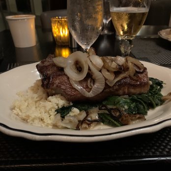 The Bay House - 12 oz NY Strip steak with cauliflower risotto and sautéed spinach with onion. - Seafood Near Me - Naples, Florida The Bay House - 12 oz NY Strip steak with cauliflower risotto and sautéed spinach with onion. - Seafood Near Me - Naples, Florida