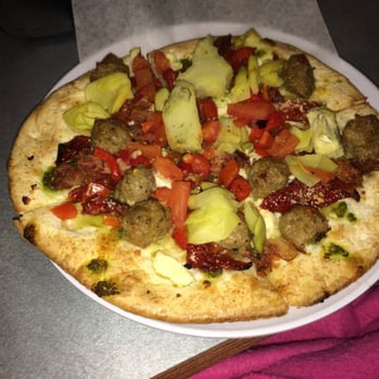 MOD Pizza - Mini with pesto drizzle, artichokes, sun dried tomatoes, roasted red peppers, spicy sausage, bacon, feta - Pizza Near Me - Houston, Texas