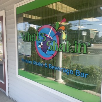 What's Shakin - the front window of a store - The window features the 'What's Shakin'' logo with colorful graphics and text indicating a protein shake and beverage bar. - Juice Bars & Smoothies Near Me - Coventry, Rhode Island