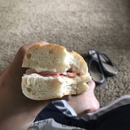 a person holding a half eaten sandwich