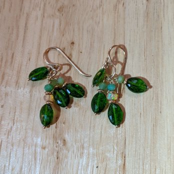 Sioux Eagle Designs - A pair of handcrafted earrings with silver hooks, green oval gemstones, and small opal beads are arranged on a light wooden surface. The earrings display detailed jewelry craftsmanship, combining vintage-style gemstones and delicate beadwork, highlighting the artistry involved in jewelry making. - Jewelry Near Me - West Tisbury, Massachusetts
