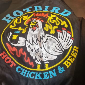Hotbird - The T-shirt. A stylized chicken with a flaming background, holding a beer.  Hotbird hot chicken & beer forming a circle around the image. - Comfort Food Near Me - Oakland, California