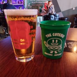 a glass of beer and a plastic cup a glass of beer and a plastic cup