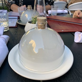 Gather - a woman sitting at a table with plates and glasses - Italian Near Me - Kelowna, British Columbia Gather - a woman sitting at a table with plates and glasses - Italian Near Me - Kelowna, British Columbia