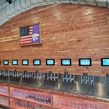 Goolsby's - a row of beer taps in front of a wooden wall - Beer Bar Near Me - Manhattan, Kansas