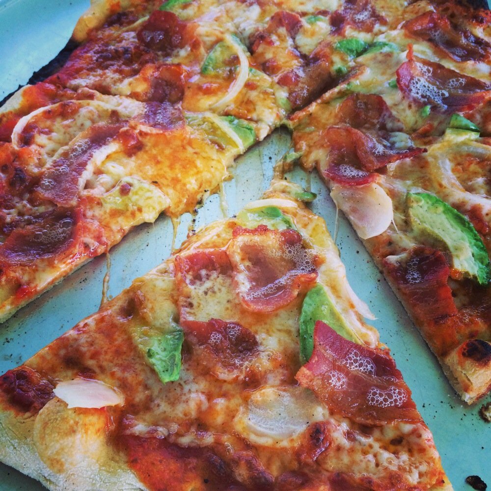 Bacon, avocado, shallot, mozzarella, and cheddar cheese brick oven pizza.