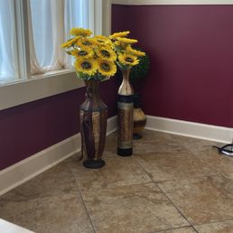 two vases of sunflowers in front of a window