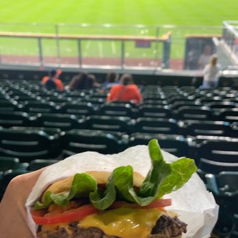 Shake Shack - a person holding a hamburger in a stadium - Burgers Near Me - Houston, Texas Shake Shack - a person holding a hamburger in a stadium - Burgers Near Me - Houston, Texas