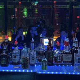 a bar filled with bottles of alcohol a bar filled with bottles of alcohol