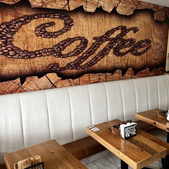 Rise & Grind - a coffee shop with wooden tables and benches - Coffee & Tea Near Me - Buffalo, New York