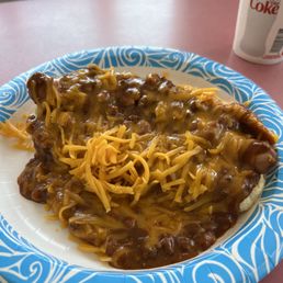 A lot of good chili with cheese mounded high covering up an excellent dog and bun. A lot of good chili with cheese mounded high covering up an excellent dog and bun.