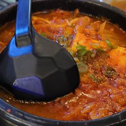 a pot of stew with a spoon in it a pot of stew with a spoon in it