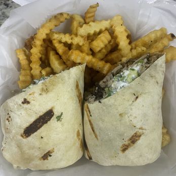 Jerky Jerk - Jerky Chicken burrito and Jerky Chicken Sandwich - A foam takeout container contains two wraps, partially opened, with crinkle-cut fries on top, served with a paper liner. - Caribbean Near Me - Rolling Meadows, Illinois