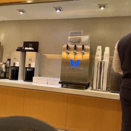 a man standing in front of a coffee machine a man standing in front of a coffee machine