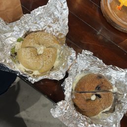 Salt bagel with avacado and cream cheese and a blueberry bagel with cream cheese Salt bagel with avacado and cream cheese and a blueberry bagel with cream cheese