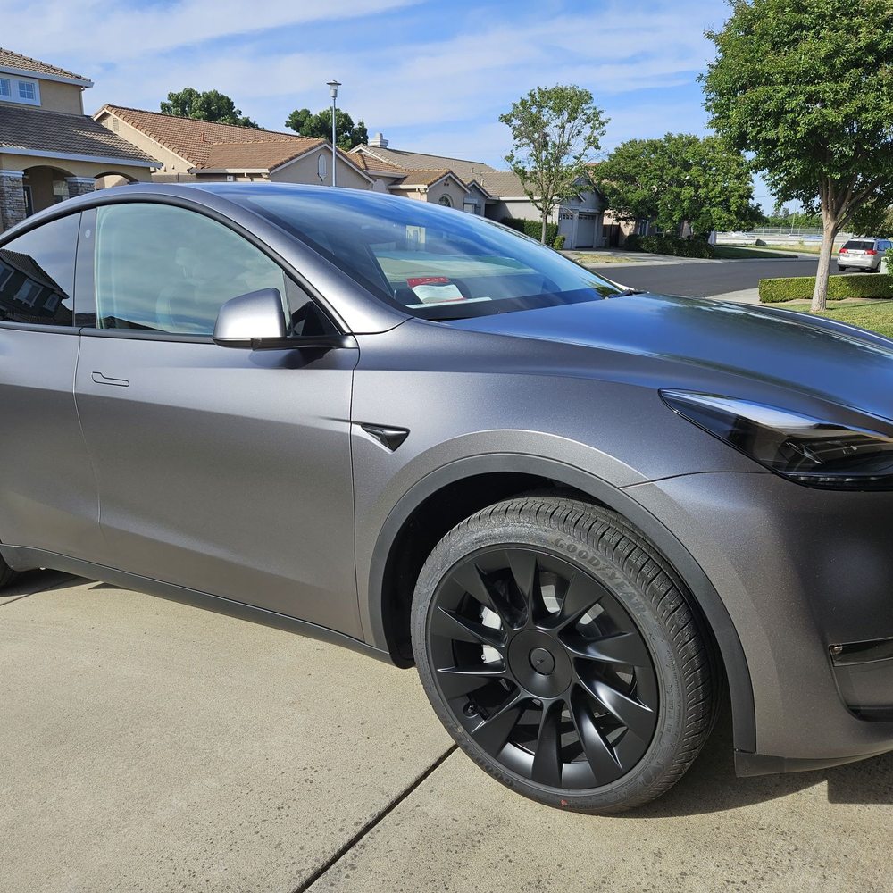 White tesla model y wrapped to satin dark grey