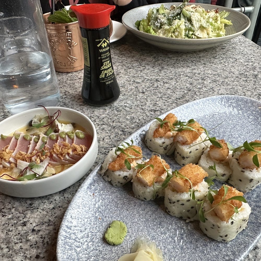 a plate of sushi and a bowl of salad a plate of sushi and a bowl of salad