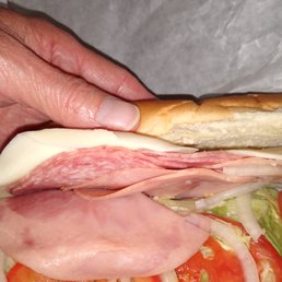 a person's hand holding a sandwich