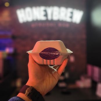 Honeybrew - a person holding a paper plate with a piece of cake in it - Bistros Near Me - Vancouver, British Columbia