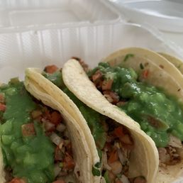 three tacos in a styrofoam container three tacos in a styrofoam container