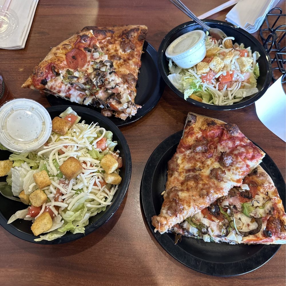 three plates of pizza and salad