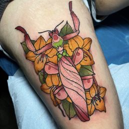 Right Thigh Tattoo - a purple and pink orchid mantis from above, framed by yellow/orange flowers and green leaves
