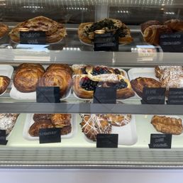One pastry display case. The fresh fruit cream cheese croissant is in the middle.