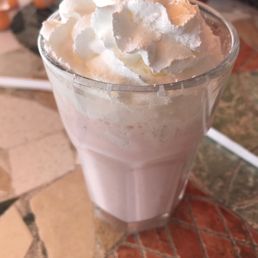 a glass of milkshake with whipped topping