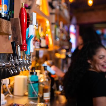 The Ave - a woman at a bar smiling - Dive Bars Near Me - San Francisco, California