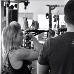 studio fit'nez - Trainer Matthew Perry working with a client on a cable bicep curl.