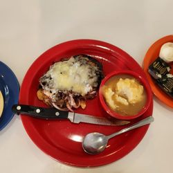 L to R: potato salad, smothered chicken entrée, mashed potatoes and gravy, side of butter and blackberry jam for the wheat toast.