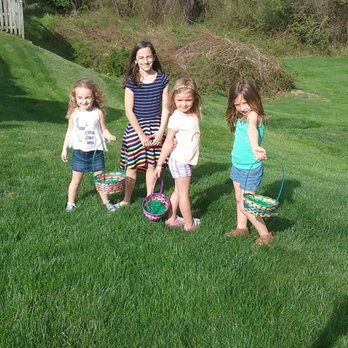 Weed Man - a woman and three children playing with a hula hoop - Lawn Services Near Me - Grasonville, Maryland