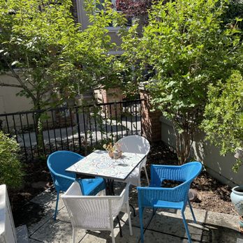 Reyes Projects - a patio with a table and blue chairs - Landscaping Near Me