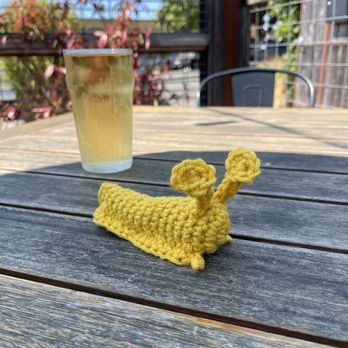 The Local Cider Bar - a yellow crocheted snail on a wooden table - Beer Bar Near Me - Arcata, California