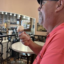 One scoop strawberry cheesecake gelato on sugar cone.