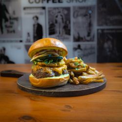 Chaplin's Café - Hamburger con aioli de cilantro, queso cheddar, toston, escabeche de pimiento rojo y cebolla ensalada y papas fritas.