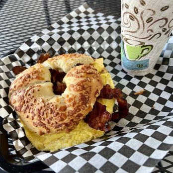 NYC Bagels and Cafe - Bacon, egg and cheese on a toasted Asiago bagel with a coffee. - Bagels Near Me - Scottsdale, Arizona NYC Bagels and Cafe - Bacon, egg and cheese on a toasted Asiago bagel with a coffee. - Bagels Near Me - Scottsdale, Arizona