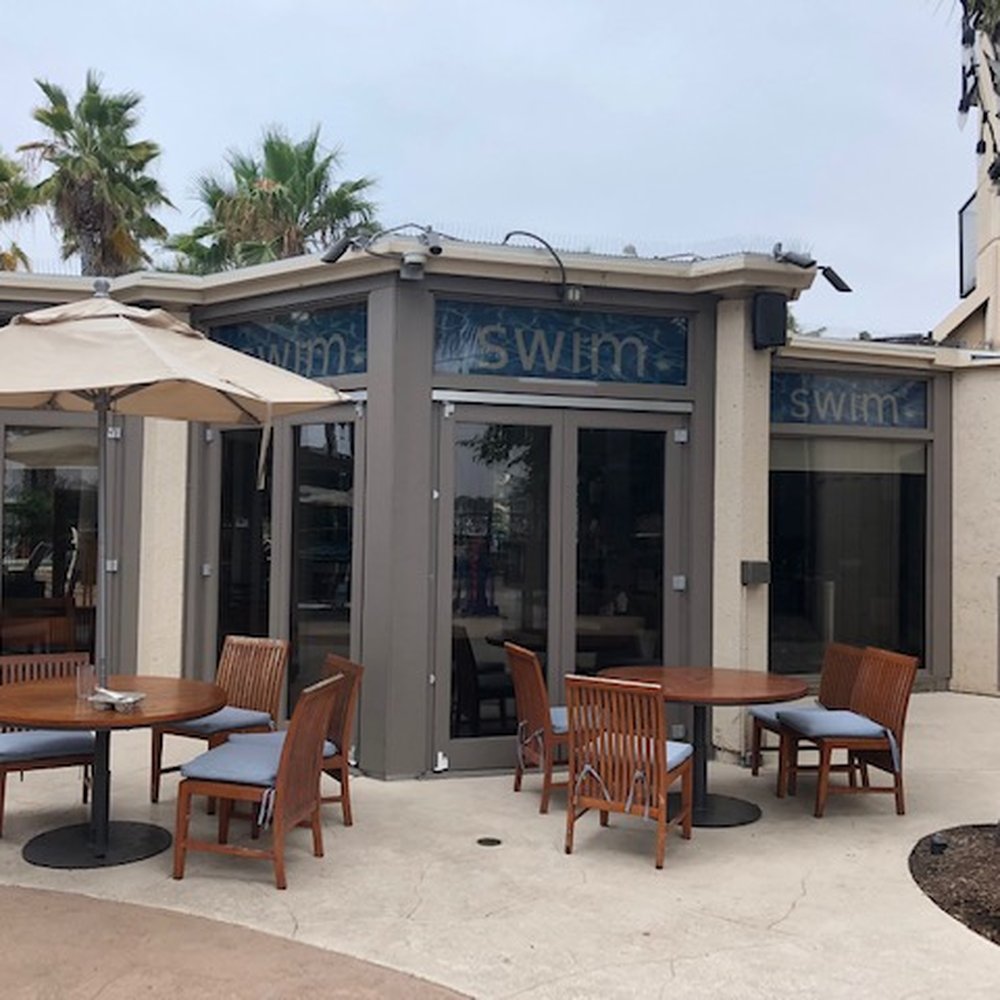 SWIM Lounge - the outside of a restaurant with tables and umbrellas - Lounges Near Me - San Diego, California SWIM Lounge - the outside of a restaurant with tables and umbrellas - Lounges Near Me - San Diego, California