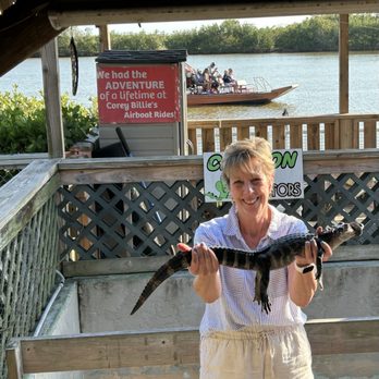 Corey Billie's Airboat Rides - Holding an aligátor, Sign & boat conveniently in the background :-) - Boat Tours Near Me - Collier, Florida Corey Billie's Airboat Rides - Holding an aligátor, Sign & boat conveniently in the background :-) - Boat Tours Near Me - Collier, Florida