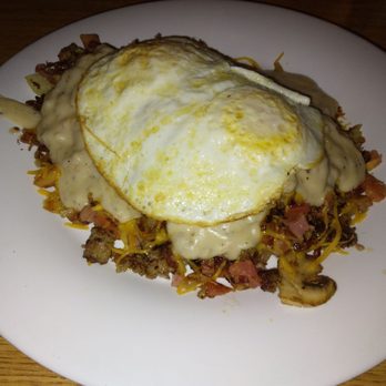 The Scrambler House - Hot Mess- Crispy home fries topped with ham, bacon, sausage, mushrooms, onions, tomatoes, cheddar, sausage gravy and 2 eggs on top. - American Near Me - O'Fallon, Missouri The Scrambler House - Hot Mess- Crispy home fries topped with ham, bacon, sausage, mushrooms, onions, tomatoes, cheddar, sausage gravy and 2 eggs on top. - American Near Me - O'Fallon, Missouri