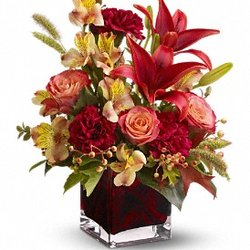 Coombs Flowers - As bright and intense as a hot Indian summer afternoon, this deep red, orange and burgundy bouquet complemented by autumn-hued oak leaves.