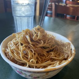 a bowl of noodles and a glass of water