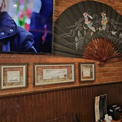 Wok n Roll Kitchen - Some of the other wall decorations, such as the giant hand fan and other framed sayings.