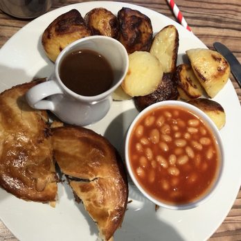 Piebury Corner - Minced beef and onion pie with gravy, roast potatoes and baked beans. - British Near Me - London, XGL Piebury Corner - Minced beef and onion pie with gravy, roast potatoes and baked beans. - British Near Me - London, XGL
