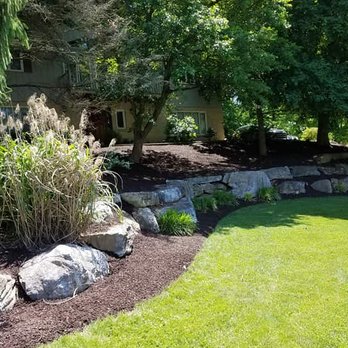 Vision Landscaping & Lawncare - a garden with a stone retaining wall - Lawn Services Near Me - Northampton, Pennsylvania Vision Landscaping & Lawncare - a garden with a stone retaining wall - Lawn Services Near Me - Northampton, Pennsylvania